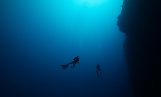 Deep underwater scene with divers
